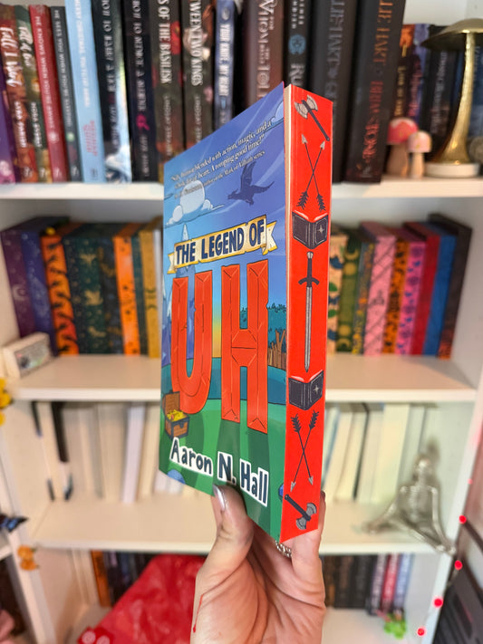 A book titled 'The Legend of UH' by Aaron N. Hall displayed in front of a bookshelf