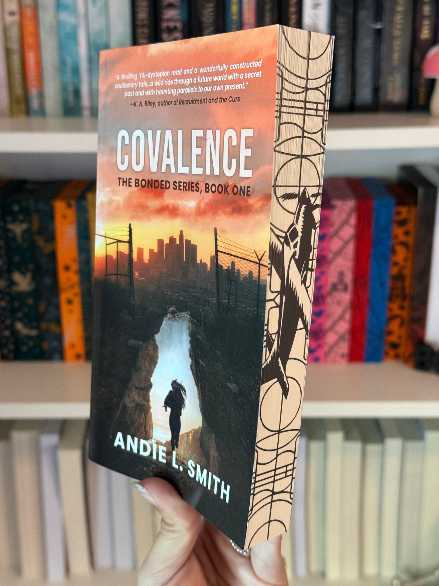 A book titled 'Convalence The Bonded Series, Book One' by Andie L. Smith displayed in front of a bookshelf